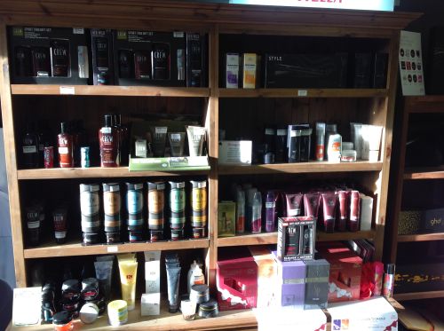 Wooden shelf and press containing American Crew shampoos conditioners and gels 2 